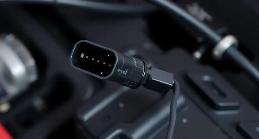 A close-up photograph of an automotive sensor, specifically an angle sensor, with visible wiring and connectors. The sensor should be slightly angled to show its components. Focus on the electrical connections and wiring harness.